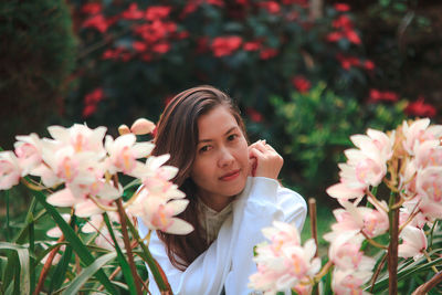 Portrait of woman by flowering plants at park