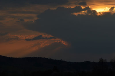 Scenic view of dramatic sky over silhouette landscape