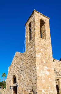 Low angle view of old building against blue sky