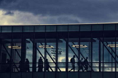 People at airport against sky in city