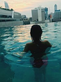 Rear view of woman swimming in pool