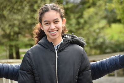 Portrait of smiling teenage girl standing outdoors