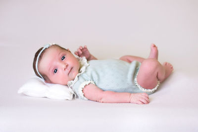 Cute baby boy lying on bed at home