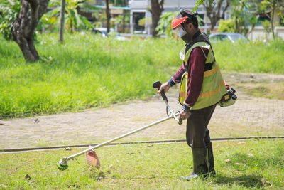 A gardener's man working with lawnmowers in the garden.