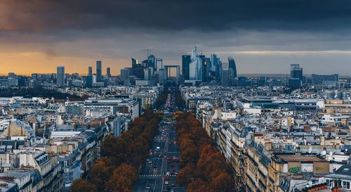 High angle view of city buildings against cloudy sky