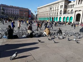 People on street against buildings in city