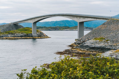 Arch bridge over river against sky