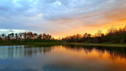 Scenic view of lake against sky at sunset