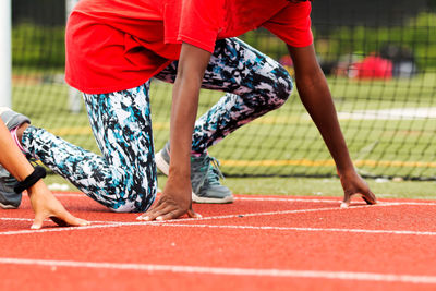 Low section of women wearing red shoes