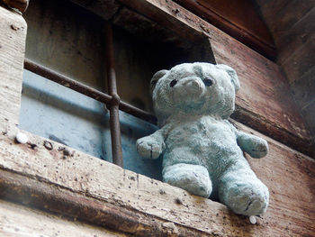 Low angle view of statue against wooden wall