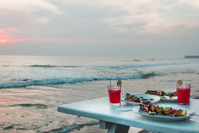 Table with cocktails, grilled food at the ocean. romantic dinner on a beach. restaurant and sea view