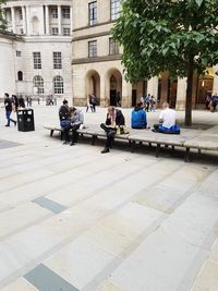 People sitting at town square with city in background