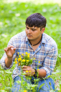 Man holding flower in field