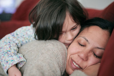 Young girl hugging mom with affection