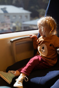 Little girl watching window while travelling by train. public transportation