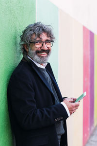 Portrait of young woman standing against wall