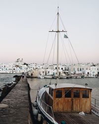 Sailboats moored at harbor against clear sky