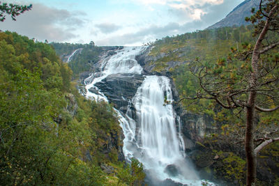 Scenic view of waterfall against sky