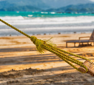 Close-up of rope on wooden post at beach