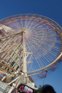 Low angle view of ferris wheel against blue sky