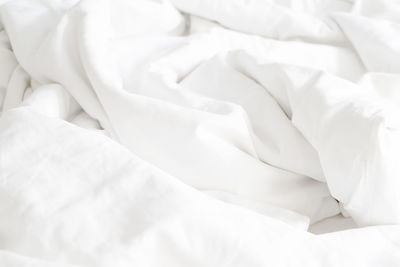 Wrinkle messy blanket and white pillow in bedroom after waking up in the morning, 