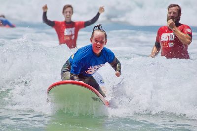 Full length of happy friends enjoying in water