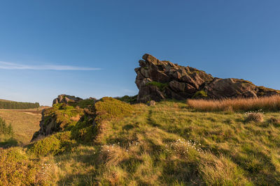 Rock formations on landscape against blue sky