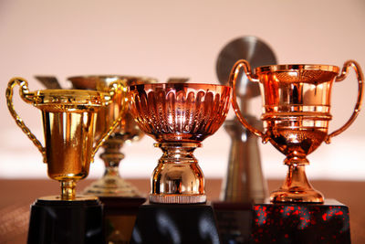 Close-up of trophies on table against wall