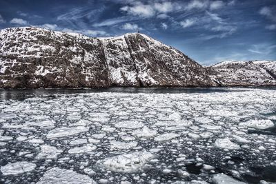 Scenic view of frozen mountains against sky