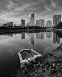 Reflection of buildings in river against sky