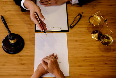 Cropped hands of male lawyer discussing with customer in office