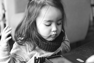 Close-up of cute girl looking at phone 