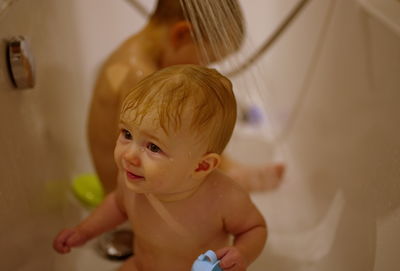Cute little children having shower in bathtub