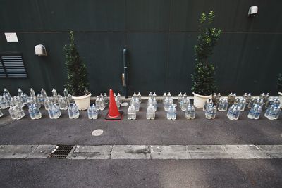 High angle view of water bottles on sidewalk by wall