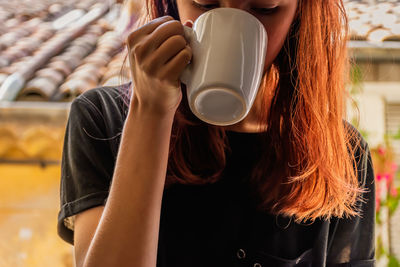 Midsection of woman drinking coffee