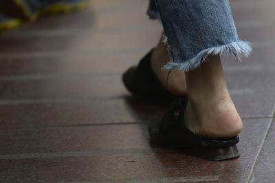 Low section of woman walking on footpath