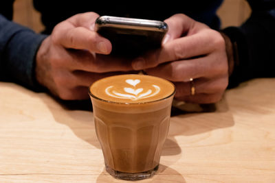 Cropped image of hand holding coffee cup