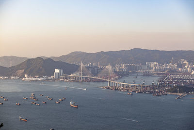 High angle view of sea by city against clear sky