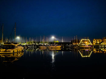 Boats moored in harbor at night