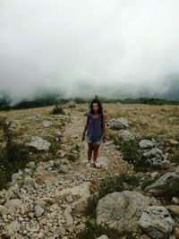 Full length of woman standing on mountain against sky