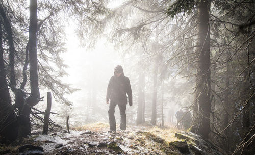 Man standing on wet road during winter