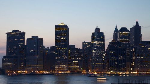 Illuminated buildings in city against sky