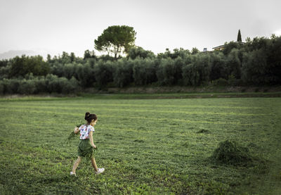 Rear view of woman standing on field