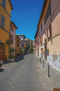 Alley with old buildings and garage under a sunny blue sky, at the town of orvieto, italy.