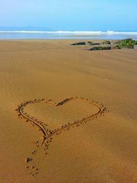 High angle view of heart shape on sand at beach