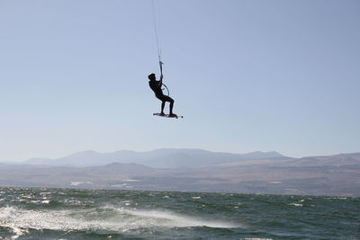 People in sea against sky