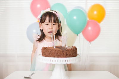 Young girl blowing candles for celebreating her 4th years birthday