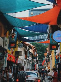 People on street against buildings in city