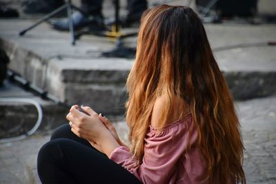 Side view of woman sitting on street