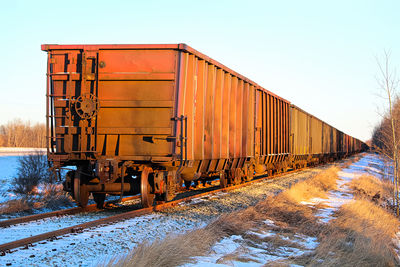 A train sitting on a track with golden sunlight on it.